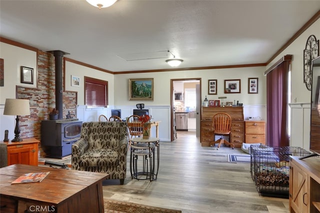 living room featuring a wood stove, wood-type flooring, and ornamental molding