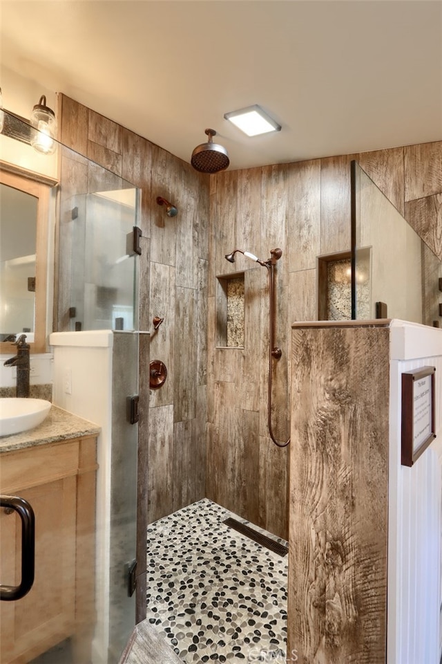 bathroom with vanity and a shower with door