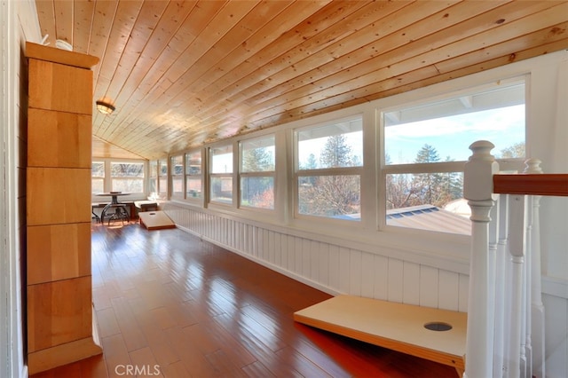 sunroom featuring a healthy amount of sunlight, wooden ceiling, and vaulted ceiling