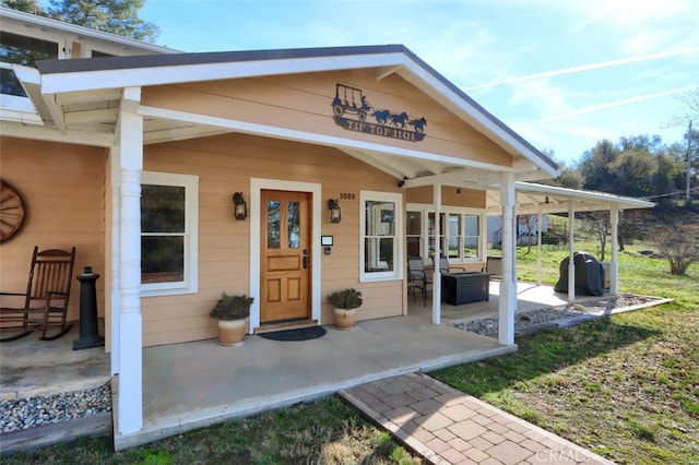 view of exterior entry with a patio