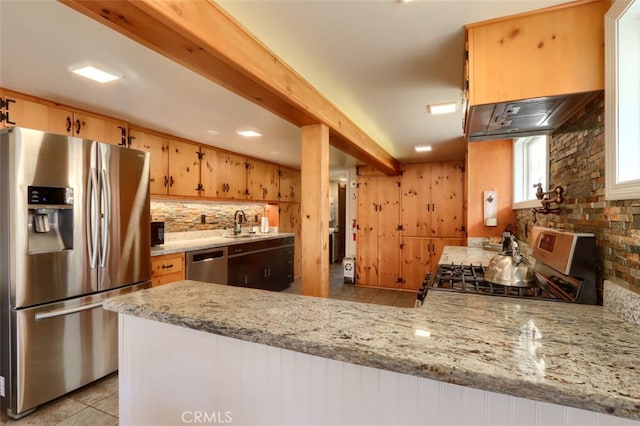 kitchen with kitchen peninsula, light stone countertops, sink, and appliances with stainless steel finishes