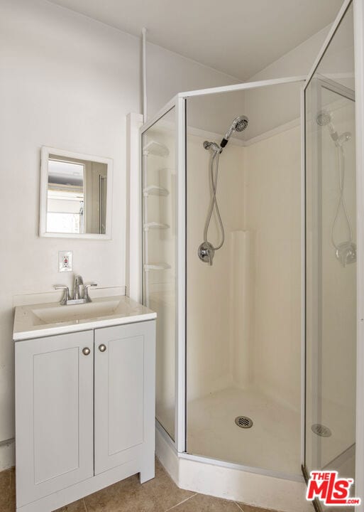 bathroom featuring tile patterned floors, vanity, and an enclosed shower