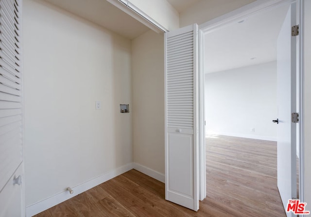 interior space featuring hookup for a washing machine and light hardwood / wood-style flooring