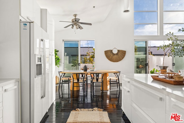 dining space with ceiling fan, dark wood-type flooring, and vaulted ceiling