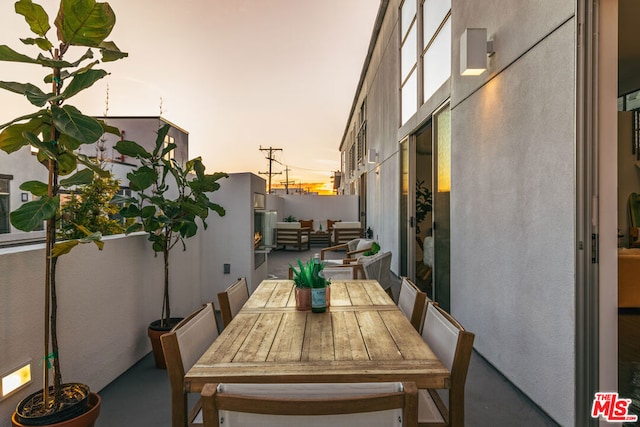 balcony at dusk featuring an outdoor hangout area