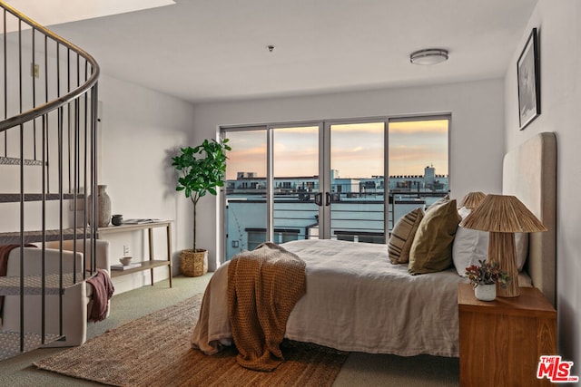 bedroom with carpet flooring, access to outside, and a water view