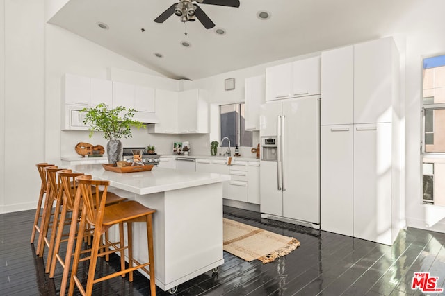 kitchen featuring ceiling fan, white cabinetry, a kitchen island, and white refrigerator with ice dispenser