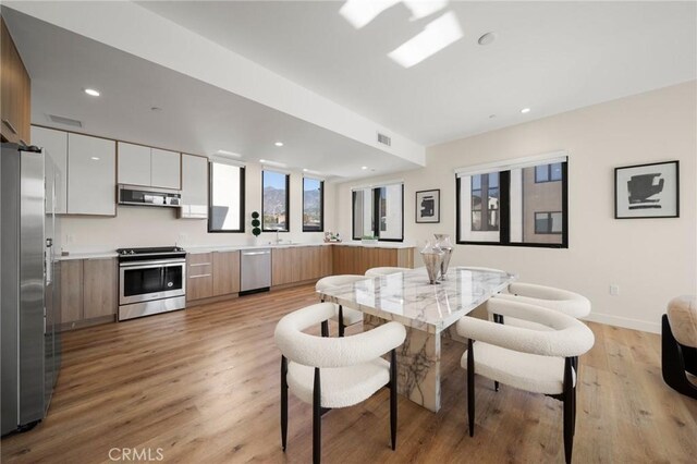 dining room with light hardwood / wood-style flooring and sink