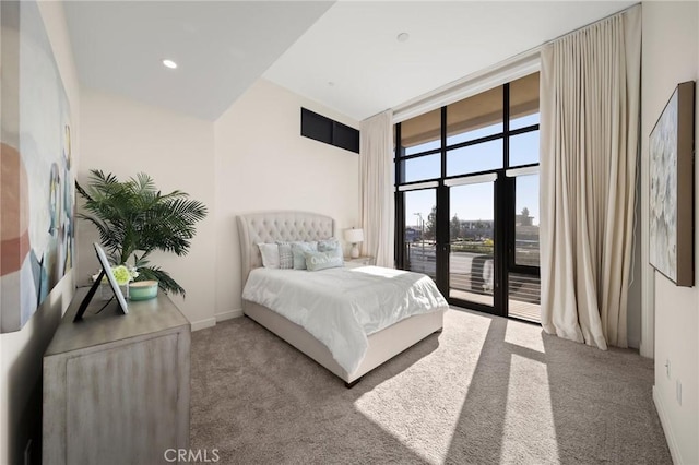 bedroom with access to outside, expansive windows, french doors, and carpet