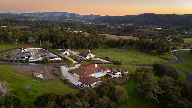 aerial view at dusk featuring a mountain view