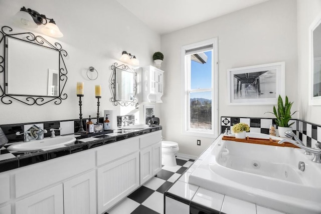 bathroom with a relaxing tiled tub, vanity, and toilet