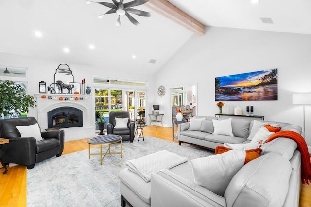 living room with beamed ceiling, ceiling fan, high vaulted ceiling, and light hardwood / wood-style floors