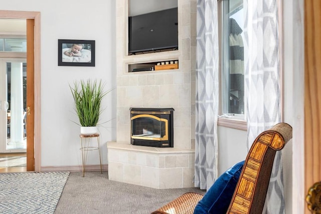 living room with a tiled fireplace and carpet flooring