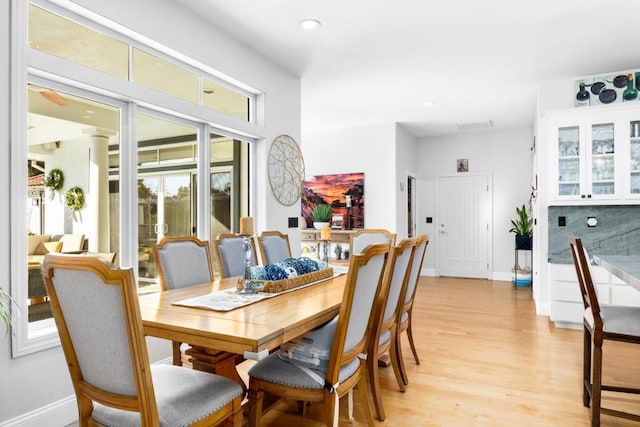 dining space with ornate columns and light wood-type flooring