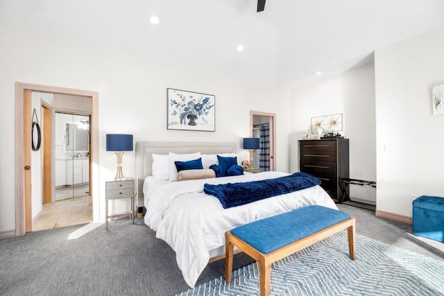 bedroom with ceiling fan, light colored carpet, and ensuite bathroom