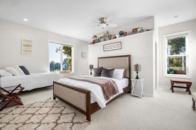 bedroom with multiple windows, light carpet, and ceiling fan