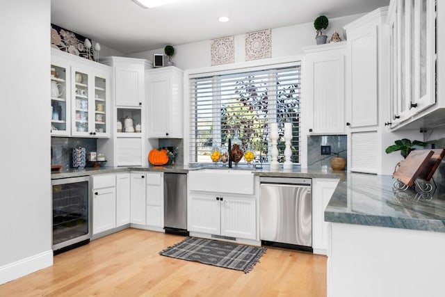 kitchen featuring white cabinetry, sink, beverage cooler, stainless steel dishwasher, and light hardwood / wood-style flooring