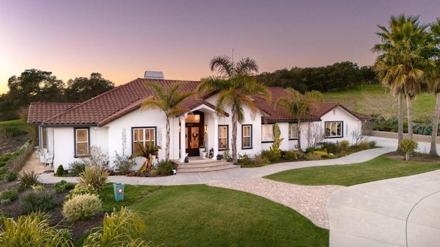 mediterranean / spanish house featuring a yard