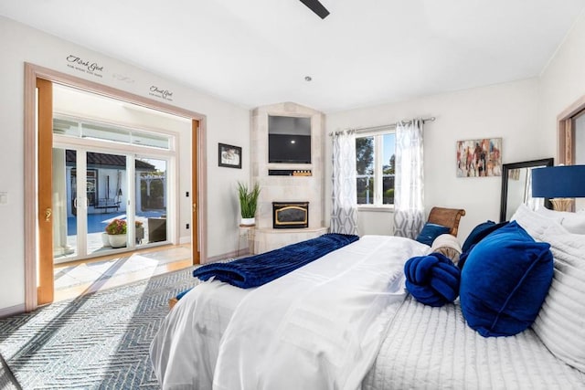 bedroom featuring a tile fireplace and access to exterior