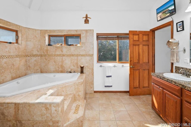 bathroom featuring vanity, tile patterned flooring, and tiled tub