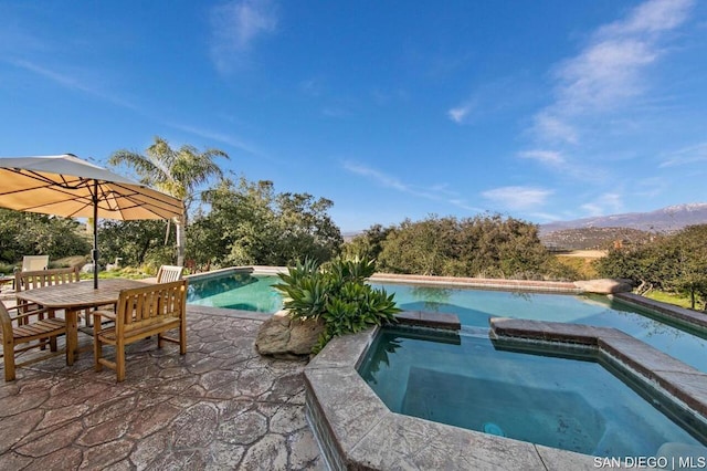 view of pool with an in ground hot tub and a mountain view