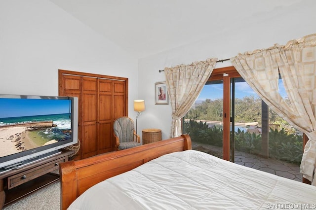 bedroom featuring lofted ceiling and access to outside