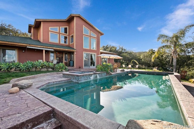 view of swimming pool featuring a patio area and an in ground hot tub