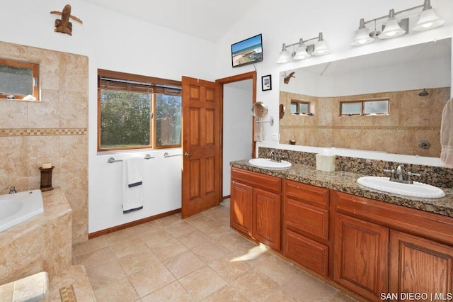 bathroom with tiled bath, tile patterned flooring, vaulted ceiling, and vanity