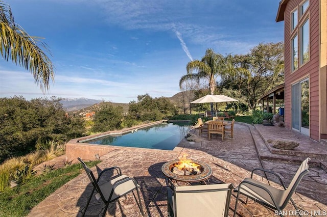 view of patio / terrace featuring a mountain view and an outdoor fire pit