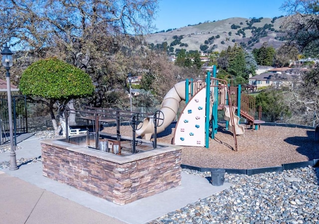 view of jungle gym with a mountain view