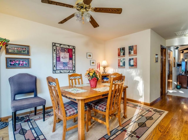 dining area with ceiling fan and dark hardwood / wood-style floors