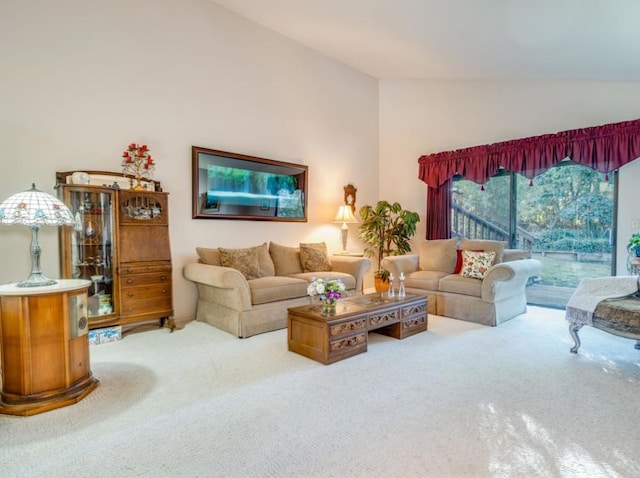 living room featuring lofted ceiling and light colored carpet