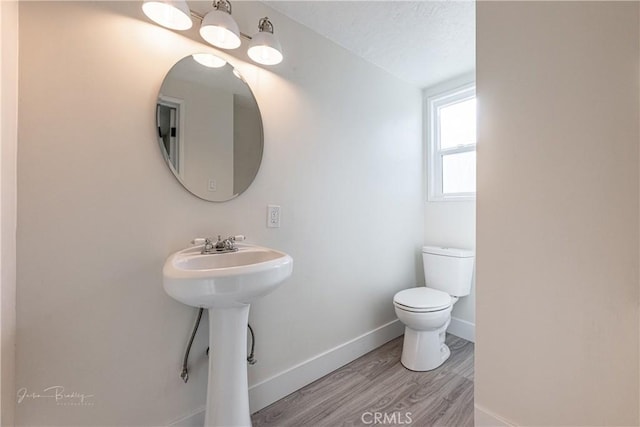 bathroom with hardwood / wood-style floors, sink, toilet, and a textured ceiling