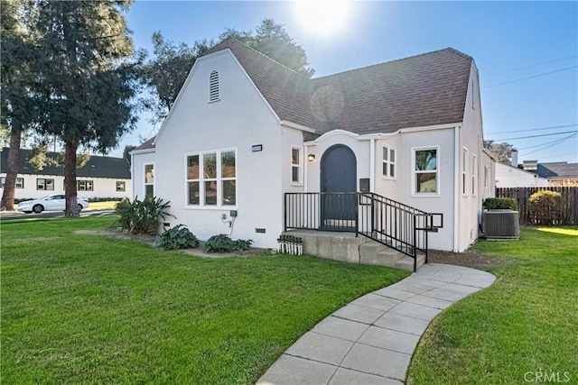 view of front of home with cooling unit and a front yard