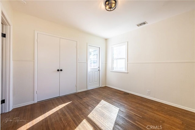 unfurnished bedroom with dark hardwood / wood-style flooring