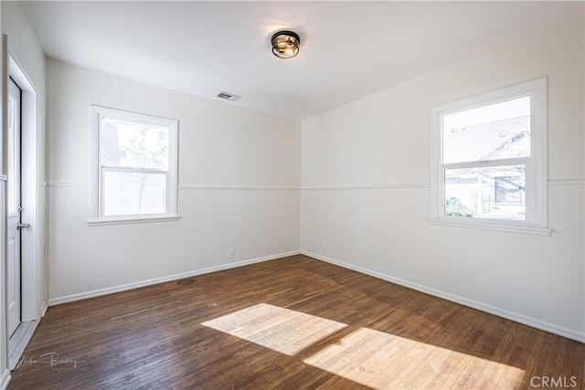 unfurnished room with dark hardwood / wood-style flooring