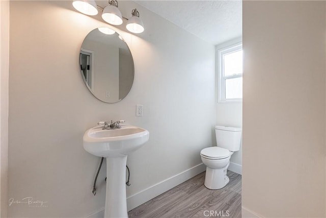 bathroom with a textured ceiling, hardwood / wood-style flooring, toilet, and sink