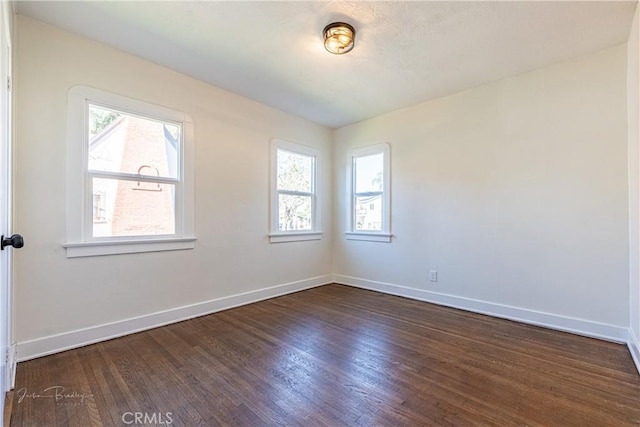 unfurnished room with a healthy amount of sunlight and dark hardwood / wood-style flooring