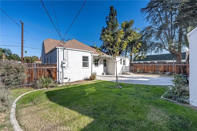 rear view of house featuring a patio area and a lawn