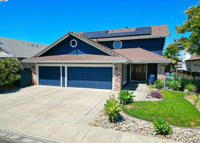 view of front of home featuring a garage, a front yard, and solar panels