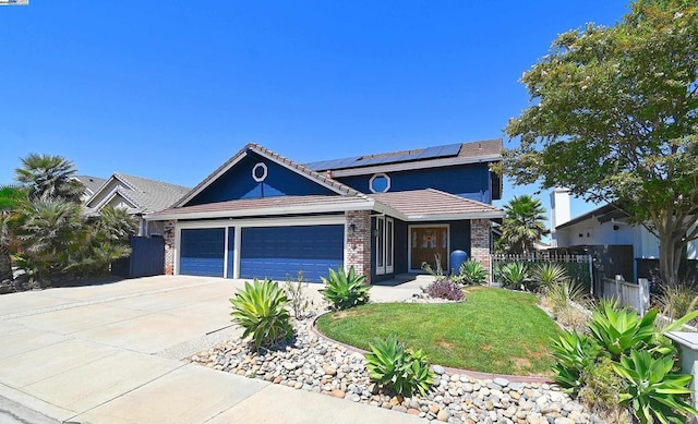 view of front of home with a front lawn, solar panels, and a garage