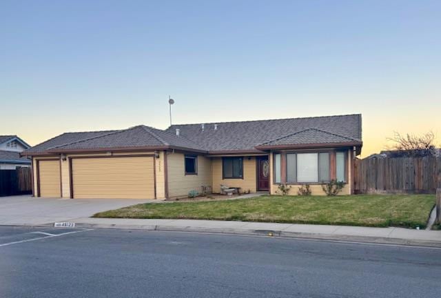 ranch-style house with a yard and a garage