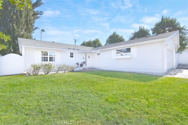 rear view of house featuring a lawn and a garage