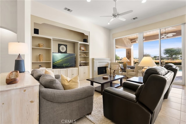 tiled living room featuring built in features and ceiling fan