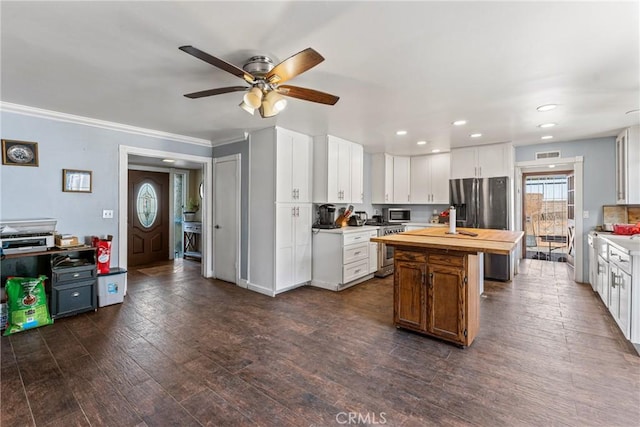 kitchen with wood counters, white cabinets, ceiling fan, dark hardwood / wood-style floors, and stainless steel appliances