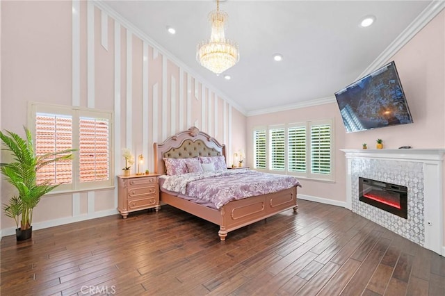 bedroom with a notable chandelier, a fireplace, dark hardwood / wood-style flooring, and crown molding