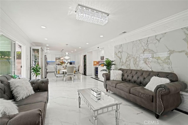 living room with an inviting chandelier, crown molding, and a premium fireplace