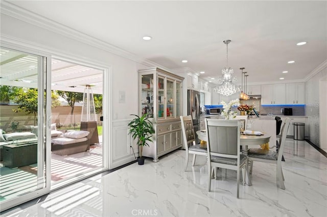 dining room with ornamental molding and a notable chandelier