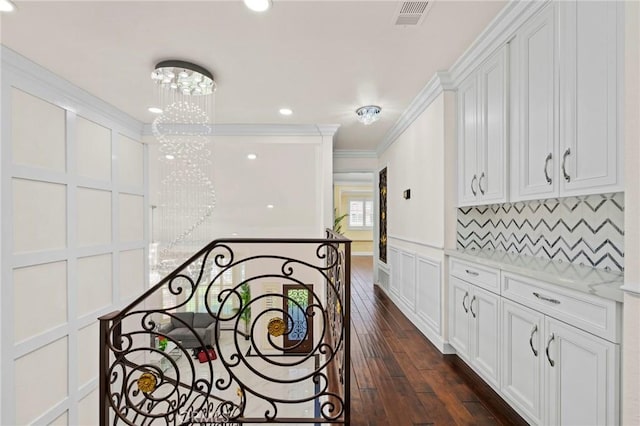 corridor featuring a chandelier, dark hardwood / wood-style floors, and ornamental molding