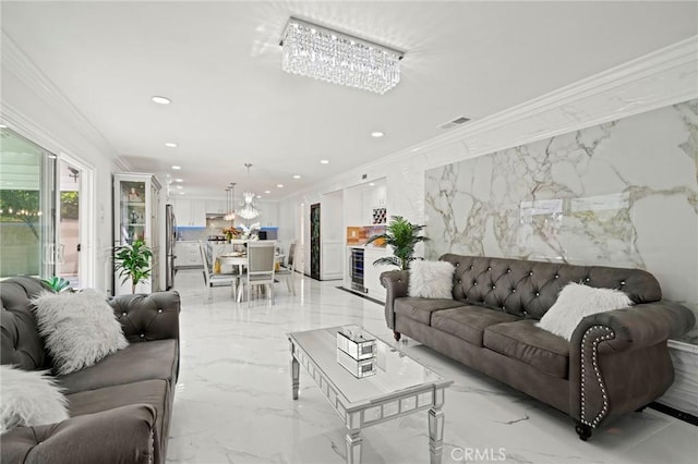 living room with a notable chandelier, a fireplace, and crown molding